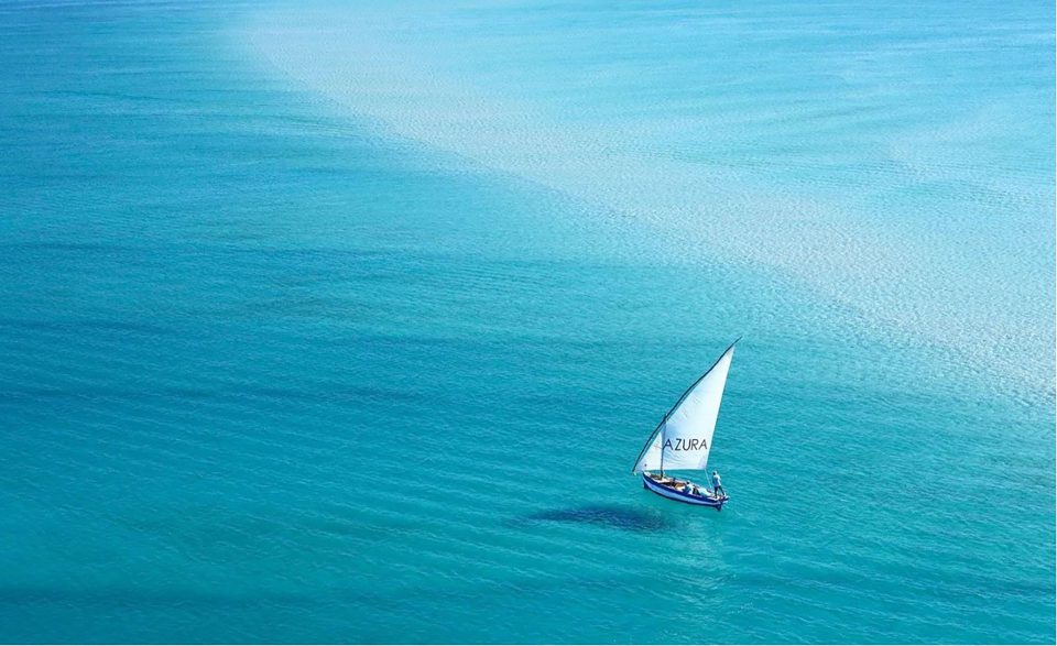 An Azura dhow out on the open, blue water