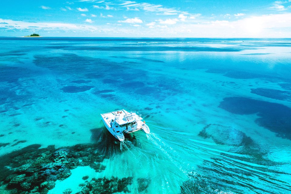 The ocean cruiser boat moving across the flat, clear blue water - Blue Safari Seychelles