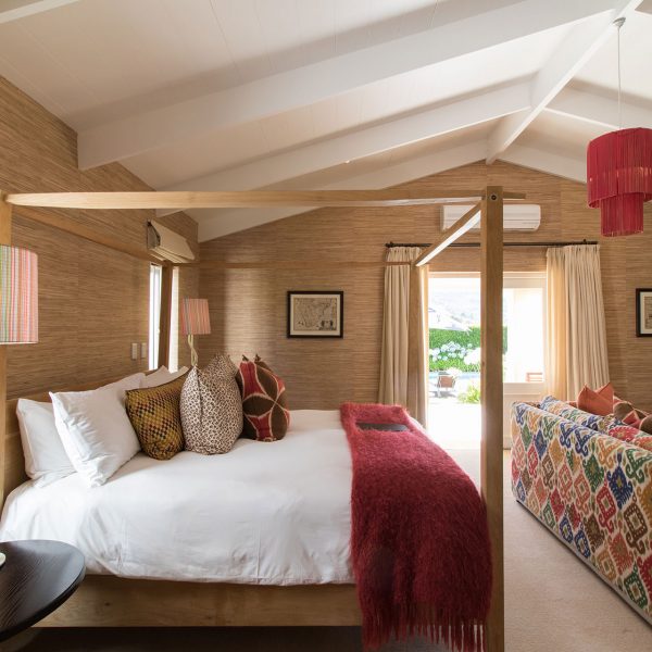 The garden suite room in Domain offers a four-poster king bed, sofa couch, and direct access to the outside areas
