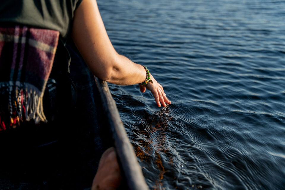 A guest drags her fingertips along the top of the water