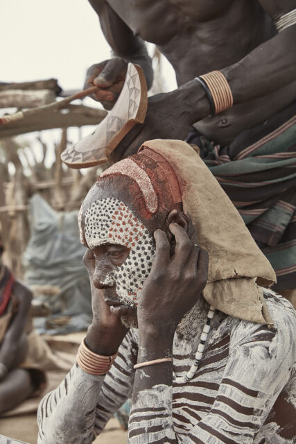 A tribesman sits in his full tribal paint
