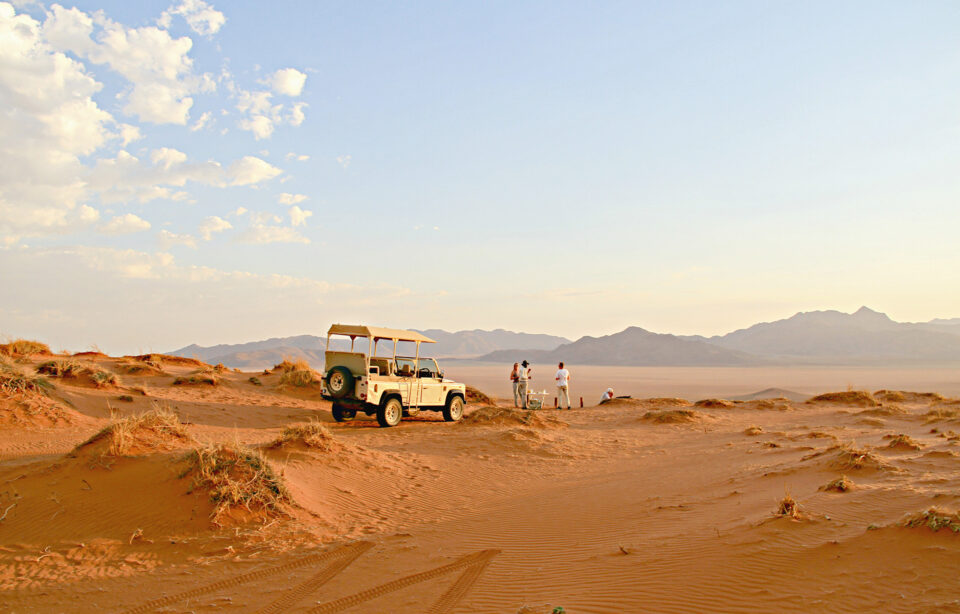 Enjoy sundowners on the edge of a dune overlooking the plains