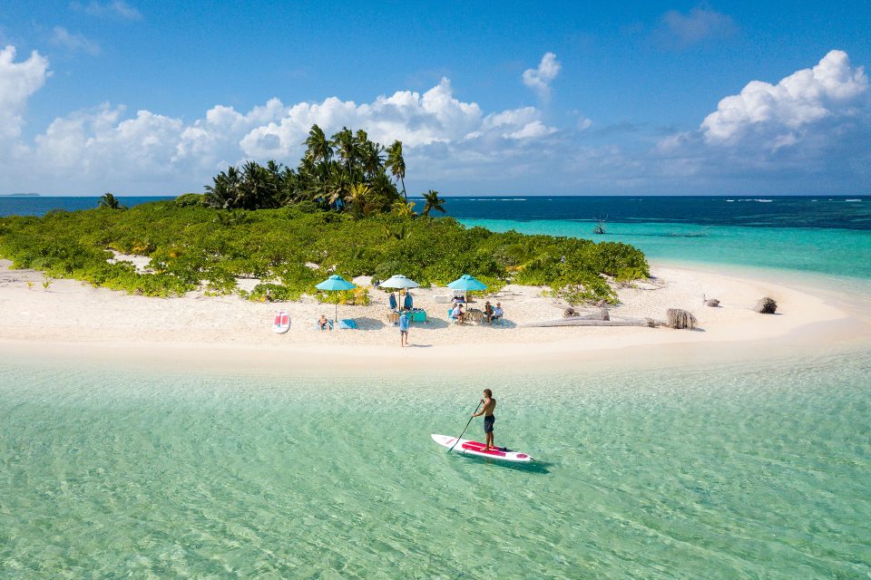 Guests enjoy a picnic while stand up paddle boarding, swimming, and fishing on Bijoutier Island